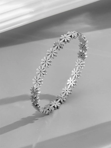 Detailed close-up of a silver daisy bracelet with rhinestones and fine metal texture