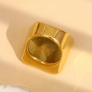 Nahaufnahme eines 18K vergoldeten quadratischen Rings mit polierter klobiger Textur