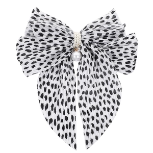 Detailed view of large black and white polka dot chiffon bow clip with pearl accent