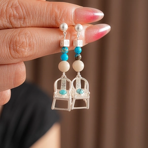 Detail of vintage silver chair earrings with blue turquoise and white beads inlay