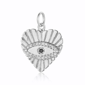 Macro detail of silver heart charm with evil eye pattern and clear zircon stones