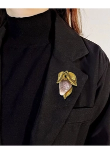 Pink enamel strawberry brooch with golden leaves pinned on a black suit lapel