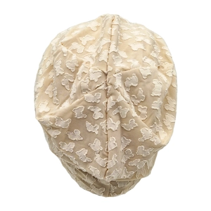 Detail of beige slouchy beanie featuring 3D butterfly embroidery and soft texture