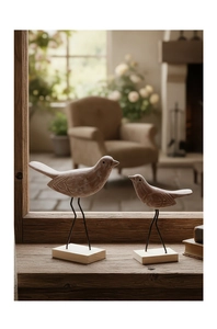 Detail van Scandinavische houten vogelfiguren met vintage houtnerf op een vensterbank