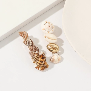 Detail shot of natural shell and golden metal hair clips with sea shell floral patterns