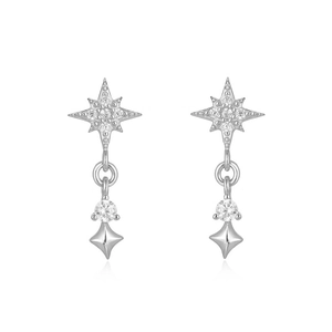 Macro detail of silver sunburst earrings featuring zircon stones and a cone pendant