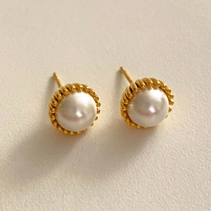 Elegant white pearl stud earrings with gold spiral base on white background