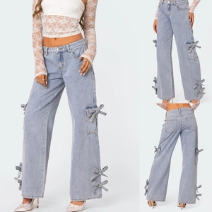 Detailed view of light blue wide-leg jeans featuring decorative bow ties on sides