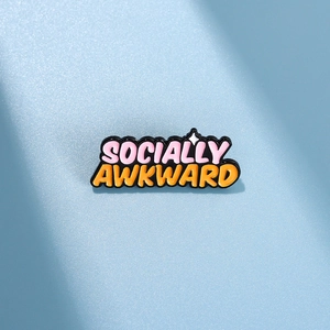 Detail of enamel pin with Socially Awkward text and star on light blue background