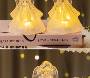 Close-up of LED glowing angel night light with warm yellow light on pink books