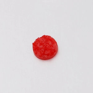 Close-up of 6mm red resin rhinestone with a sparkling mineral texture for DIY jewelry