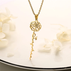 Macro view of gold rose pendant with custom script name on elegant chain necklace