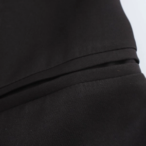 Detailed texture of black woven fabric on a double-breasted long trench coat jacket