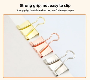 Detailed view of rose gold and silver binder clips clamped on paper with strong spring grip