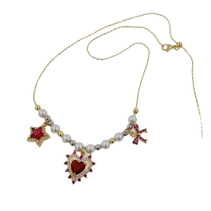 18K gold plated necklace with artificial pearls, red heart and bow charms on white background