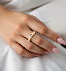Detail of S925 sterling silver twisted ring with two-tone gold and silver finish on finger
