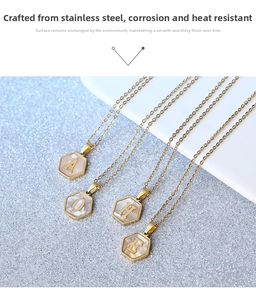 Close-up of hexagonal 18K gold-plated steel pendants with iridescent mother-of-pearl letters
