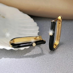 Detail of rectangular black enamel gold earrings with a central cubic zirconia inlay