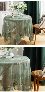 Detail of green lace tablecloth with floral patterns and elegant ruffled edges on a round table
