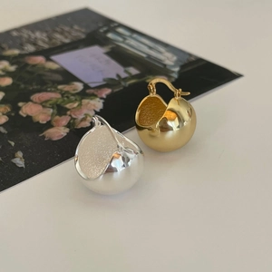 Polished silver and gold round hoop earrings with frosted interior on floral background