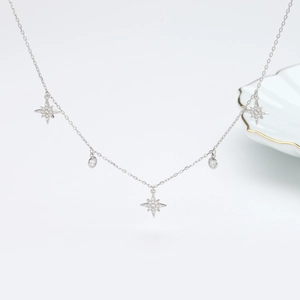 Macro shot of silver S925 necklace featuring zircon-encrusted star and round pendants