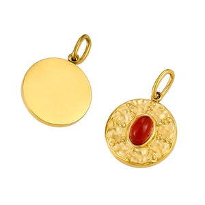 Close-up of golden geometric round pendants featuring red natural stones and hammered texture