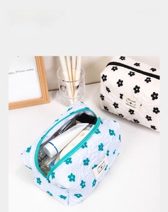 Detail of cute floral makeup pouches featuring quilted fabric and large zip opening
