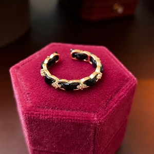 Macro di un anello a catena placcato oro con inserto in pelle su velluto rosso