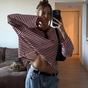 Detail view of a slim fit red and white striped long sleeve t-shirt with blue jeans