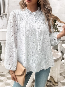 Detail of white blouse featuring hollow eyelet embroidery and ruffled stand collar