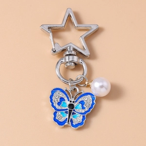 Detail of blue enamel butterfly keychain with sparkling rhinestones and white pearl charm