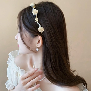 Gros plan détaillé du serre-tête floral et boucles d'oreilles perles sur modèle
