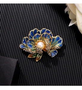 Detail of enamel peony brooch with blue-green petals, pearl center and crystal accents