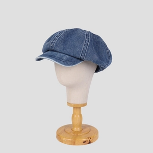 Retro dark blue denim newsboy cap for women shown on a model stand from a front view