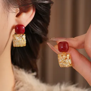 Elegant gold square earrings with red accents and sparkling rectangular zircon stones
