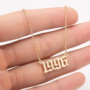 Detail of 1996 gothic year pendant in gold finish on a delicate stainless steel chain