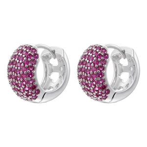 Macro detail of silver huggie earrings with pink zircons and hollow heart pattern