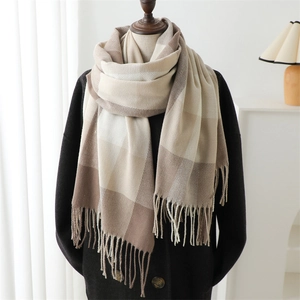 Detail of beige and brown checkered scarf with soft fringe on a black coat model