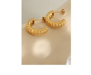 Detailed view of gold-plated C-shape earrings with vintage textured spiral design