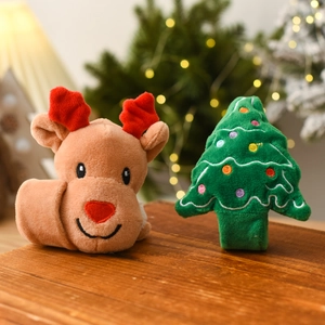 Close-up of plush reindeer and Christmas tree snap bracelets on a festive wooden table
