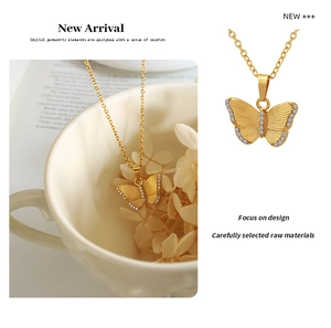 Close-up of golden butterfly pendant with sparkling zircon inlay and fine link chain