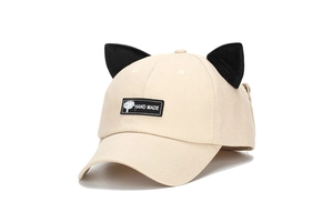 Detail of creative beige baseball cap featuring black cat ears and Hand Made patch logo