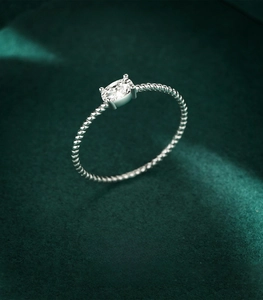 Macro shot of 925 sterling silver twisted rope ring with oval cubic zirconia on velvet