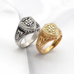 Bague bouclier rétro avec motif croix gaufré en argent et or sur fond de tissu blanc