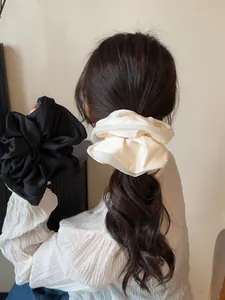 Close-up of premium silk satin oversized scrunchies in black and beige colors