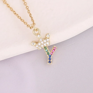 Detailed close-up of 18K gold letter Y crown pendant with colorful pavé cubic zirconia