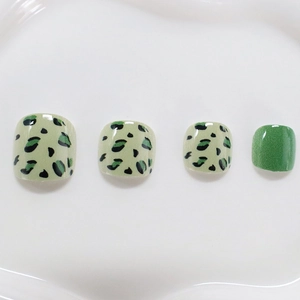 Short green leopard print press-on toenails set featuring glitter accent finish