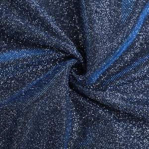 Détail macro du tissu bleu foncé avec des paillettes argentées scintillantes et maille