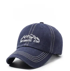 Detail of washed cotton baseball cap with white mountain embroidery and yellow stitching