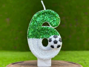 Détail d'une bougie d'anniversaire chiffre 6 verte pailletée avec décor football